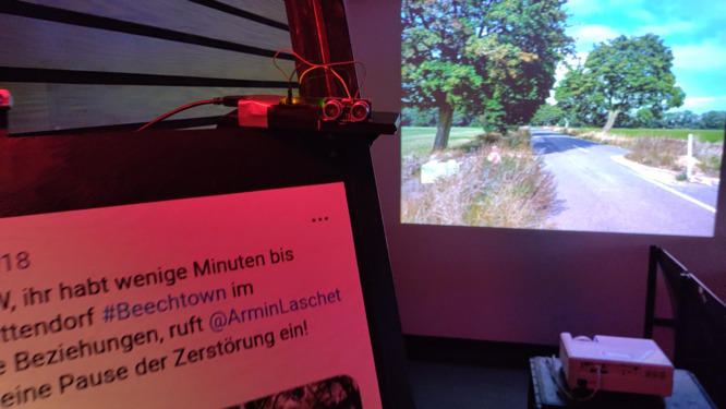 A printed screenshot and a beamed image of a road and trees.